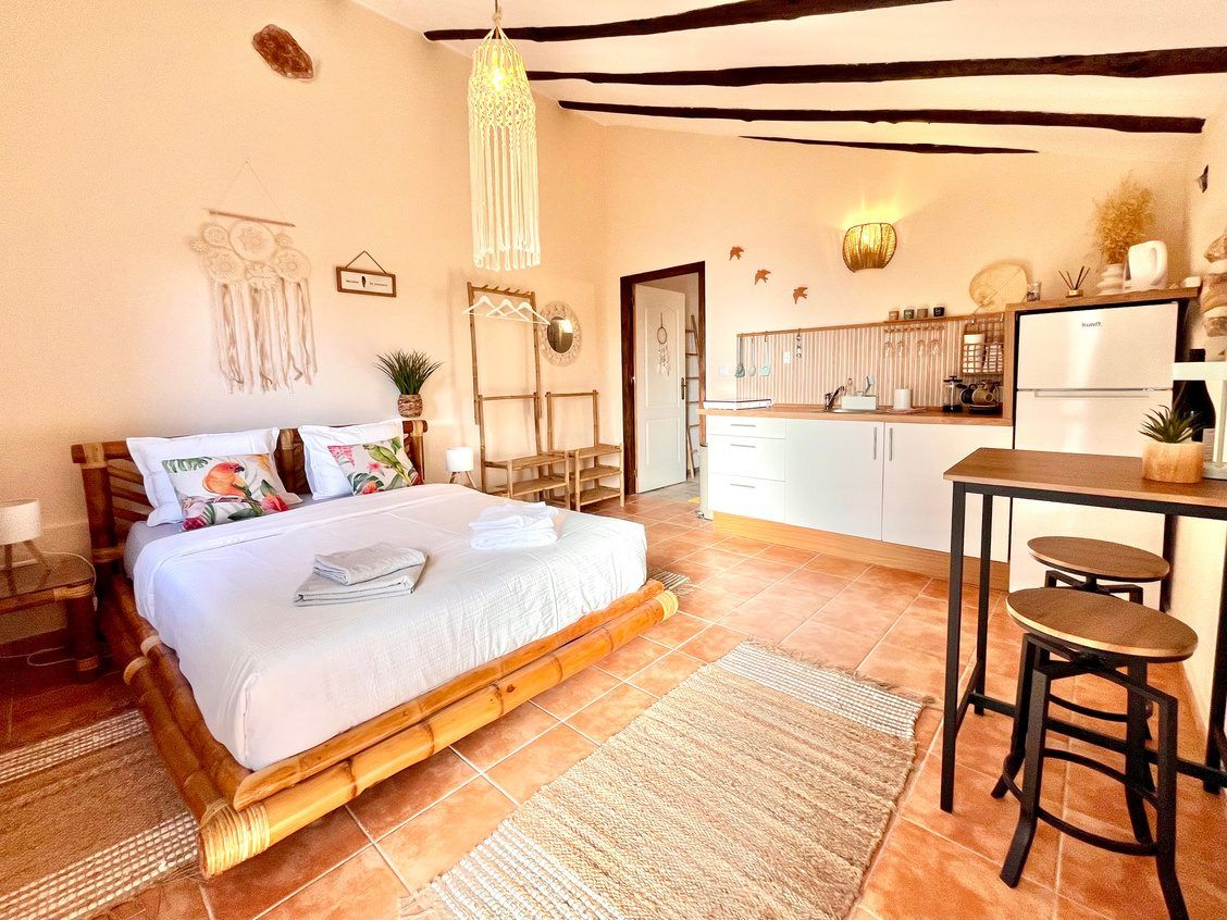 The apartment: bamboo bed, kitchen counter, a table by the window