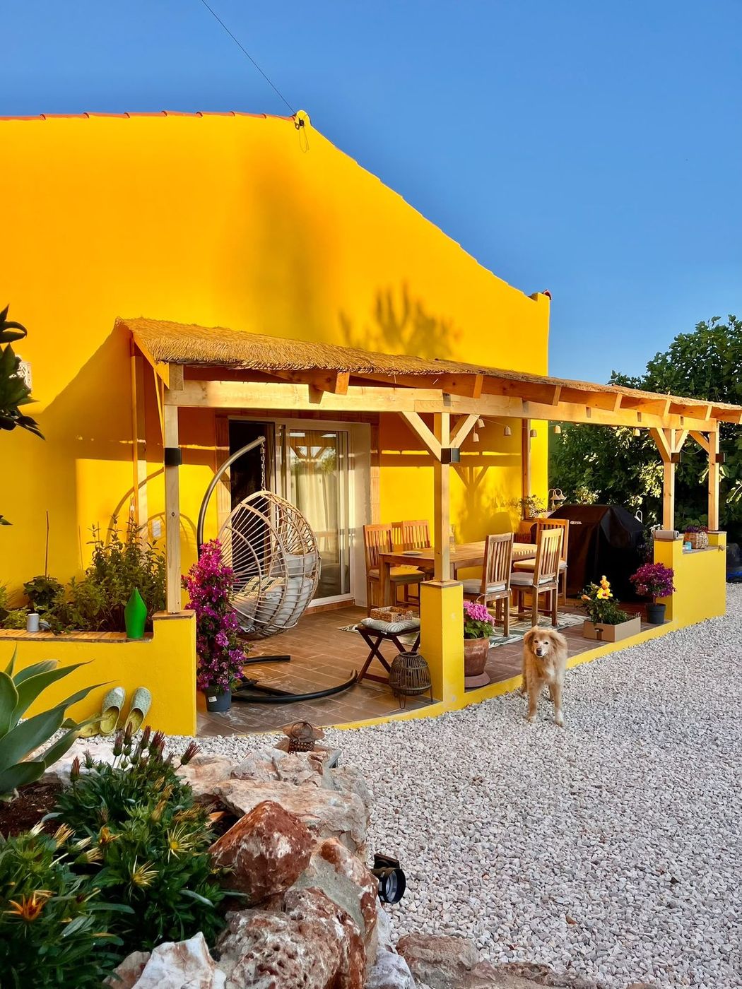 The yellow house with its pergola and long table